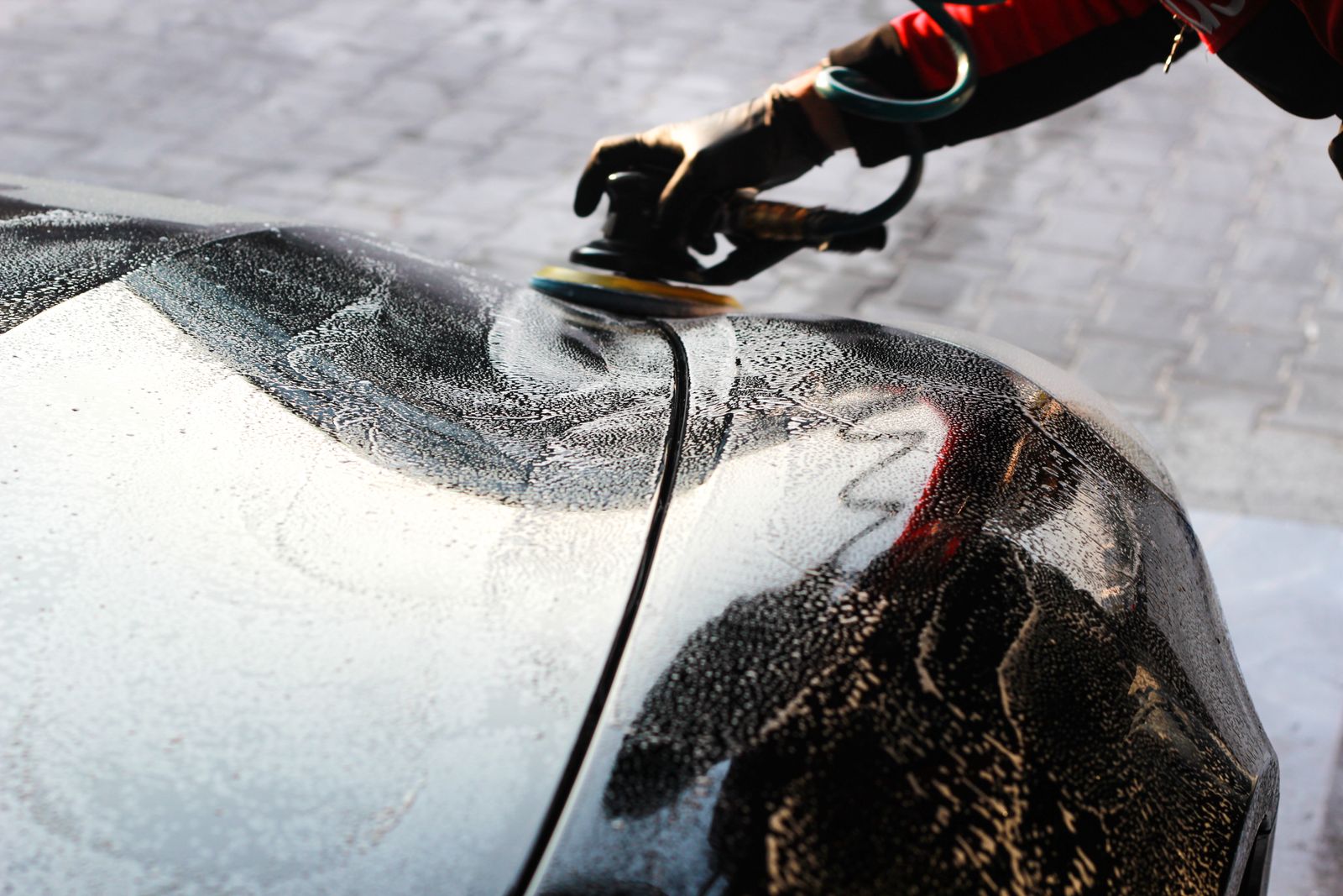 Paint reflection close-up photograph - car being polished by hand