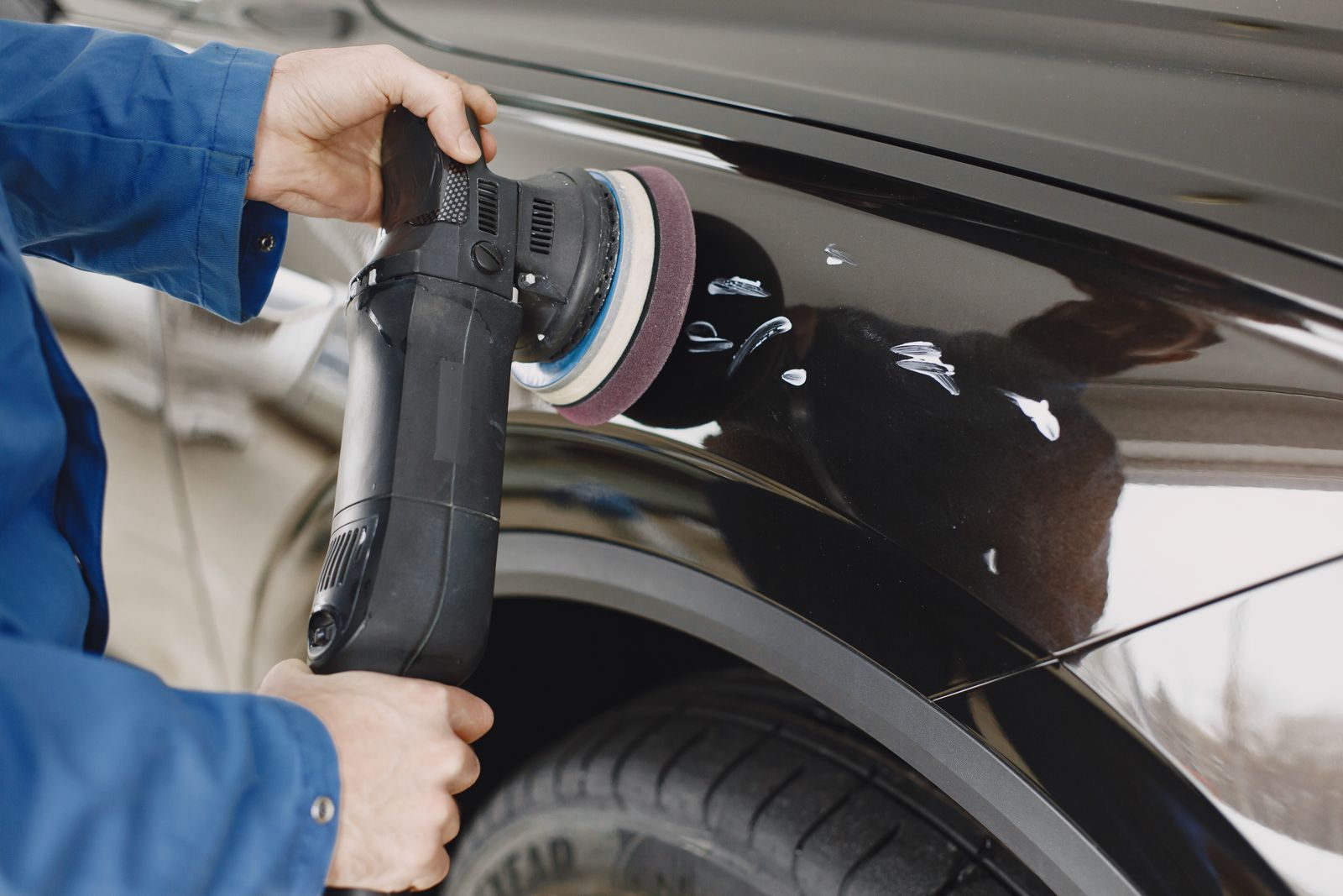 Detailing close-up - hands using a polishing machine on a car surface